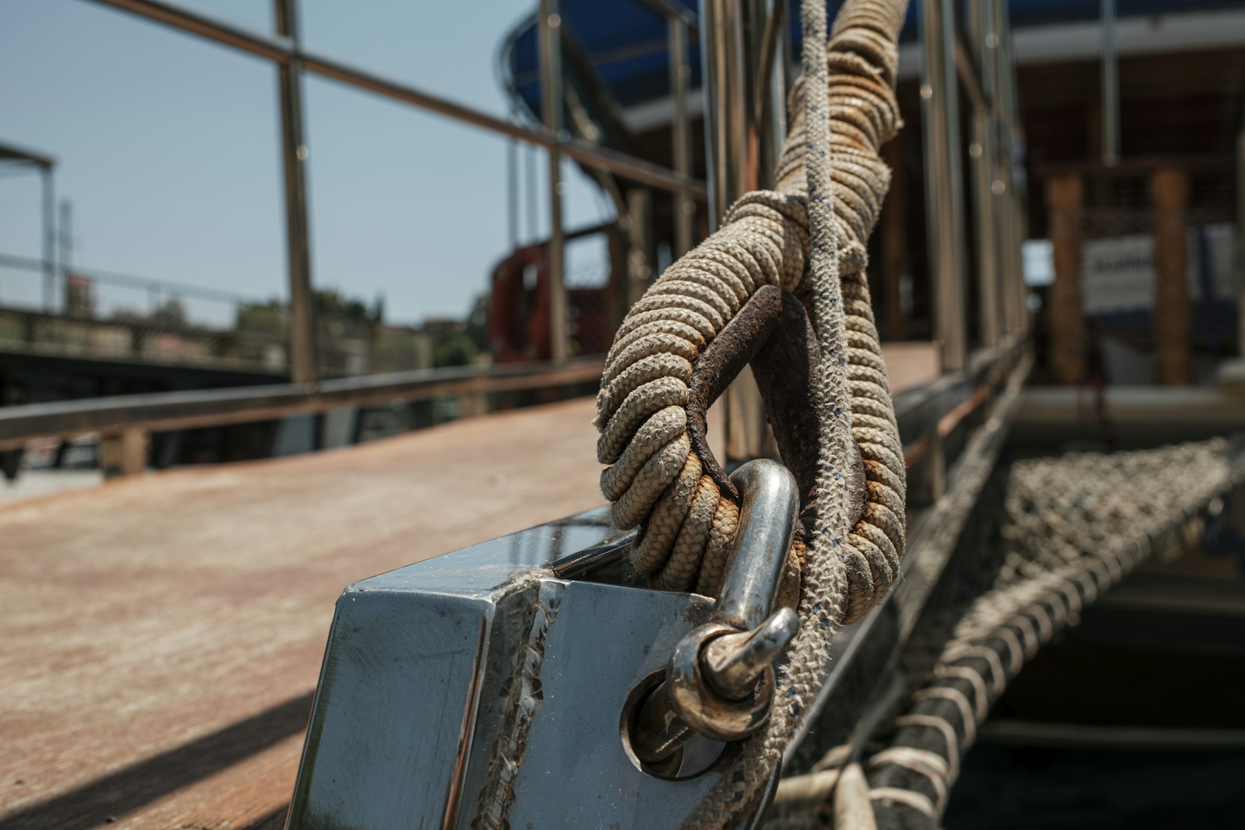 A worn mooring line looped through a steel shackle on a ship's deck